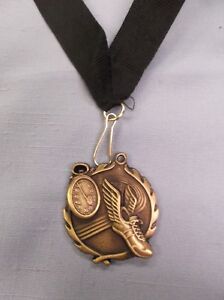 winged shoe gold medal track with black neck ribbon trophy award