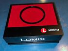 Lumix L Mount Dealer stand for camera lens in red and black plastic, velvet top
