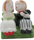 A Bride and Groom Shaped Salt and Pepper Shakers on Bench