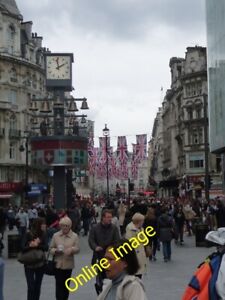 Photo 6x4 London: the Glockenspiel clock, and flags over Coventry Street  c2012