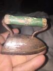 Small vintage child’s iron with green wooden handle