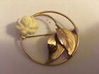 white flower with gold tone circle of life brooch