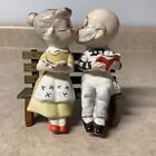 Vintage old man and woman kissing on a bench salt and pepper shakers￼