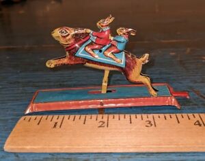 VINTAGE TIN LITHO MECHANICAL PENNY TOY 2 BUNNIES RIDING ON RABBIT GERMANY? #1116